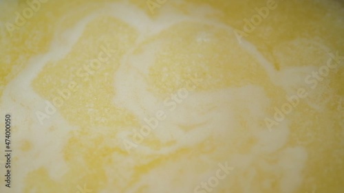 Ghee is clarified butter. Boiling yellow butter with small white bubbles.