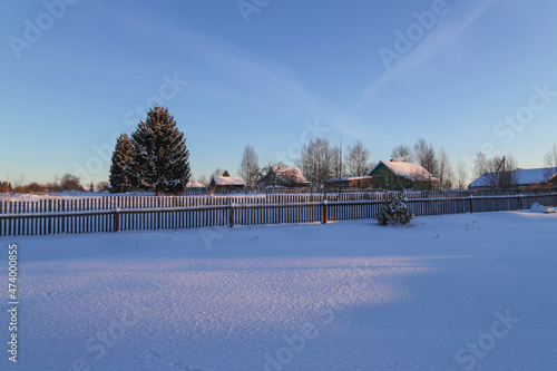 View of the village and wooden houses from the backyard on a winter sunny day. Frosty weather. Beautiful rural landscape 