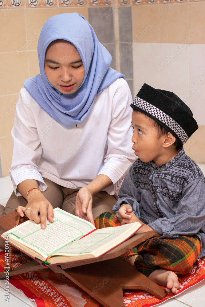 an Asian mother is teaching her son to read Al-Qur'an an Asian mother is teaching her son to read Al-Qur'an