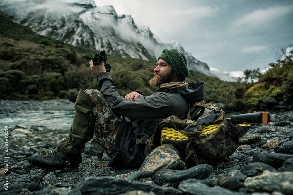 Hunter in mountains looking at view Hunter in mountains looking at view