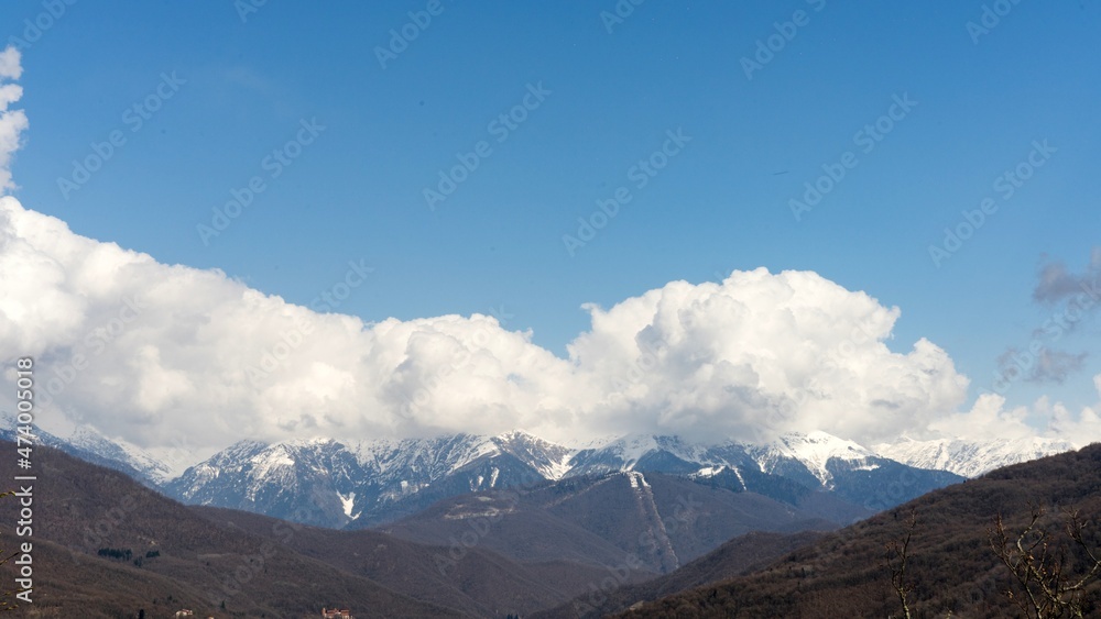 Snow capped mountains in the clouds. Caucasian mountains. Sochi Krasnaya Polyana. Russia.