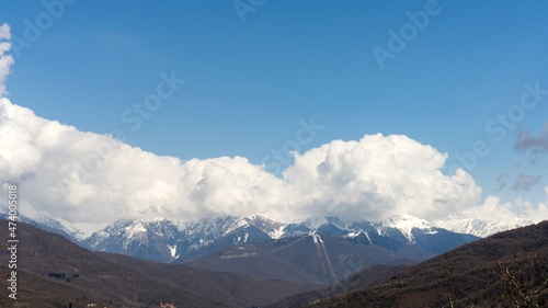Snow capped mountains in the clouds. Caucasian mountains. Sochi Krasnaya Polyana. Russia.