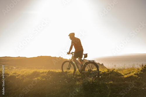 Wallpaper Mural Mature male athlete riding mountain bike at sunset Torontodigital.ca