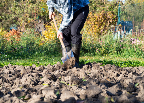 Man digging the garden soil with spade, detail