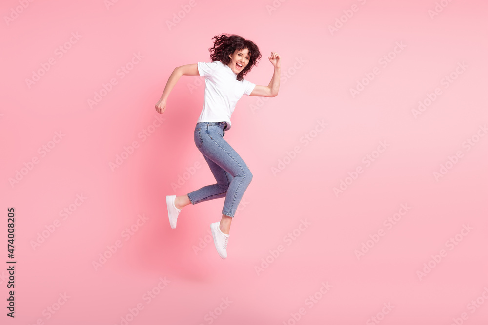 Full size profile side photo of young woman jumper go walk hurry isolated over pink color background Full size profile side photo of young woman jumper go walk hurry isolated over pink color background