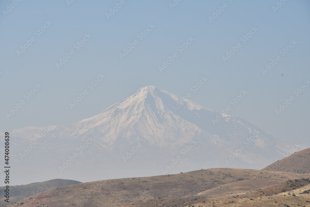 Panoramic view of the mountains and the snow-capped peak of Mount Ararat. The top of the mountain in the fog.
