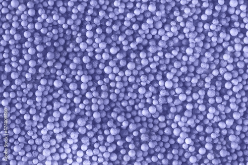 Color of the year 2022. Many light violet blue balls for children playground. Cosmetics powder. Candy sprinkles. Top view. Trendy abstract background or backplate for your design