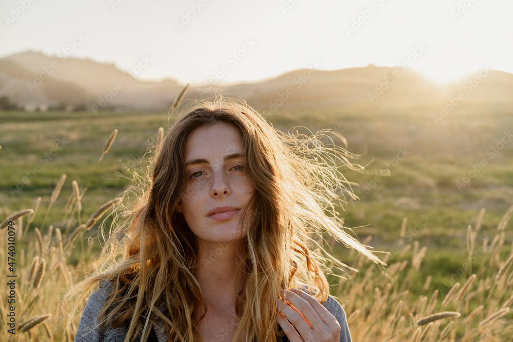 Young woman in agricultural field during sunset Young woman in agricultural field during sunset