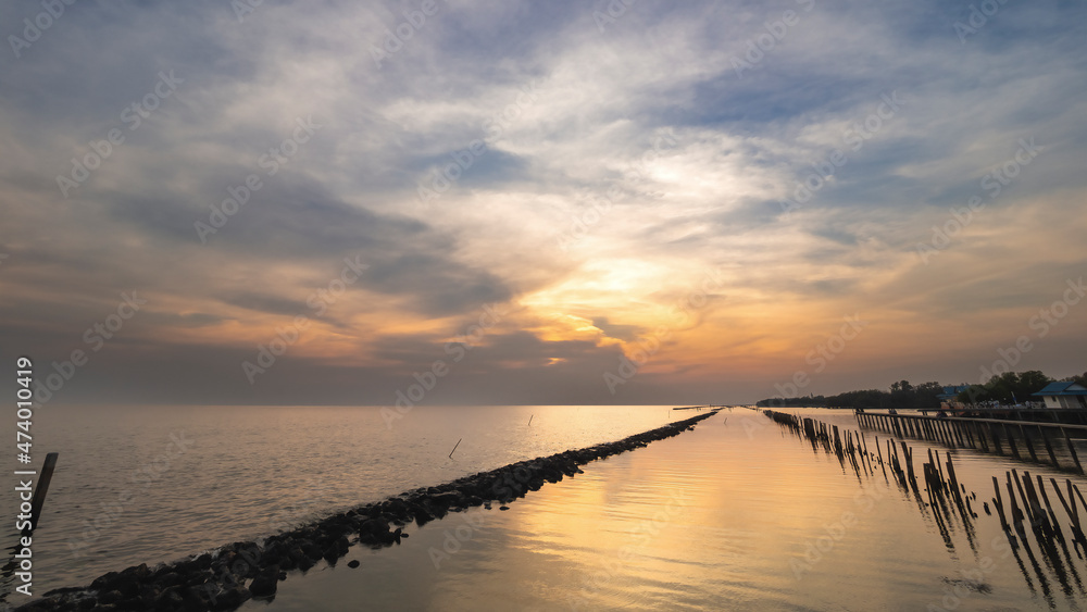 Sea view with rock and bamboo line to slow waves when twilight, Samut Sakhon, Thailand