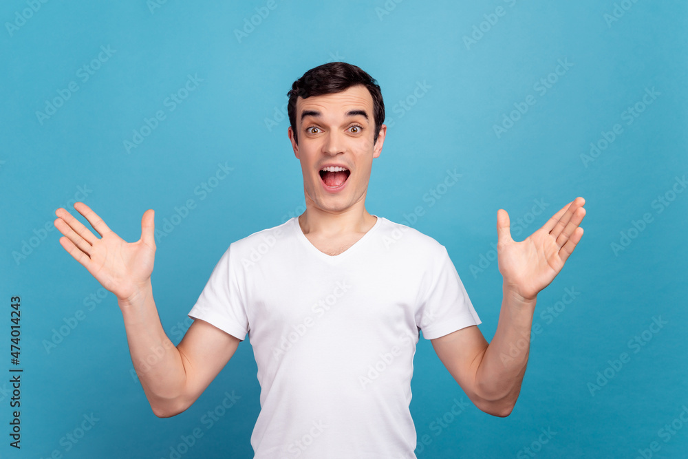 Photo of young excited man arms amazed shock omg wow good news reaction isolated over blue color background Photo of young excited man arms amazed shock omg wow good news reaction isolated over blue color background
