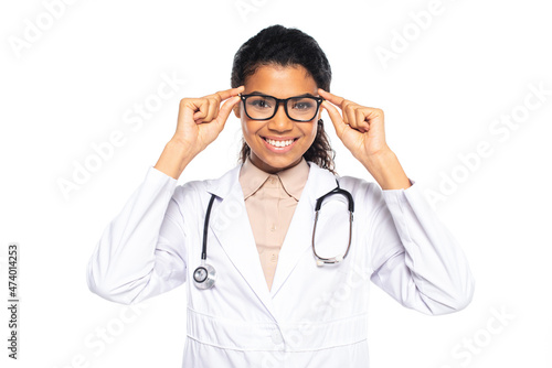 Smiling african american oculist holding eyeglasses isolated on white.