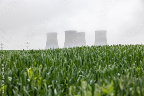 UK, England, Rugeley, Large cooling towers during foggy weather with field in foreground