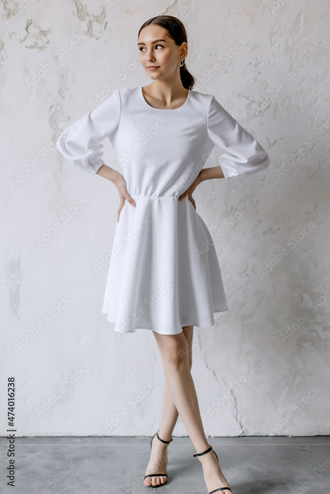 Young beauiful happy bride wearing white wedding dress and posing in bright empty interior Young beauiful happy bride wearing white wedding dress and posing in bright empty interior