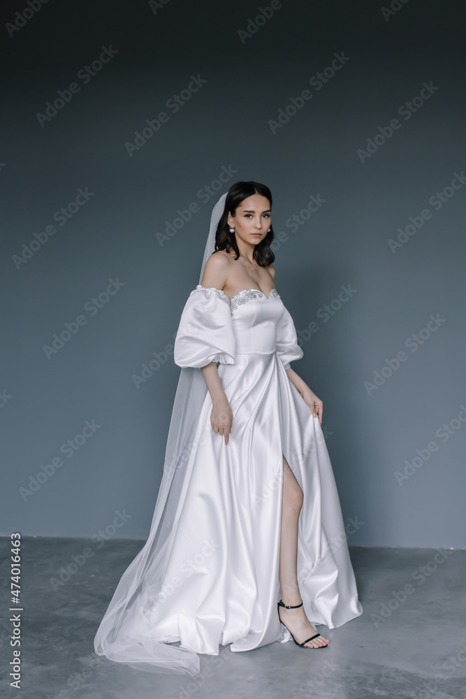 Beautiful bride in a white dress posing at the camera Portrait of a brunette woman Beautiful bride in a white dress posing at the camera Portrait of a brunette woman