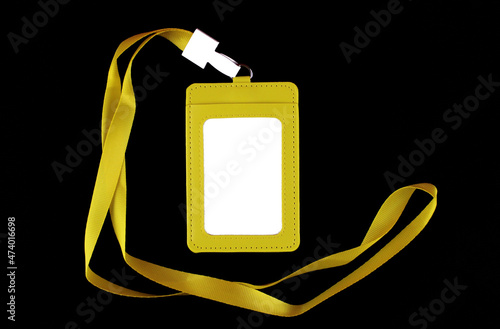Blank white badge in a yellow case with a yellow drawstring on a black background