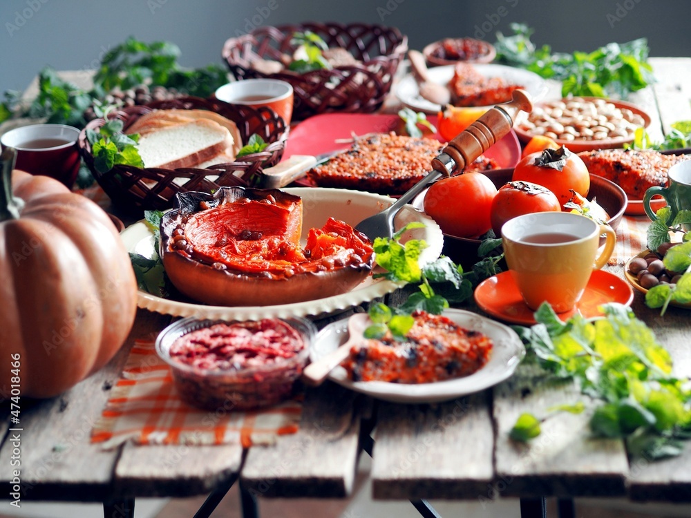 Thanksgiving Day. Simple homemade healthy rustic food using pumpkin. Various dishes at the table. Side view. Thanksgiving Day. Simple homemade healthy rustic food using pumpkin. Various dishes at the table. Side view.