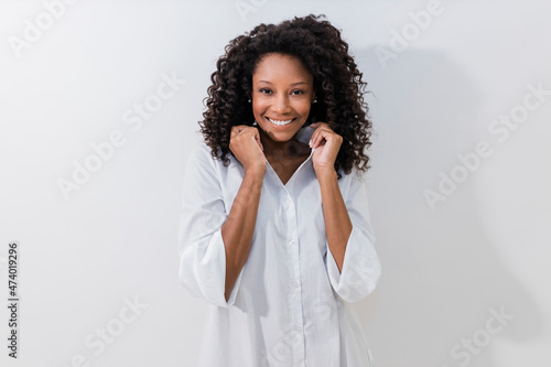 Young woman smiling while holding collar against white background photo