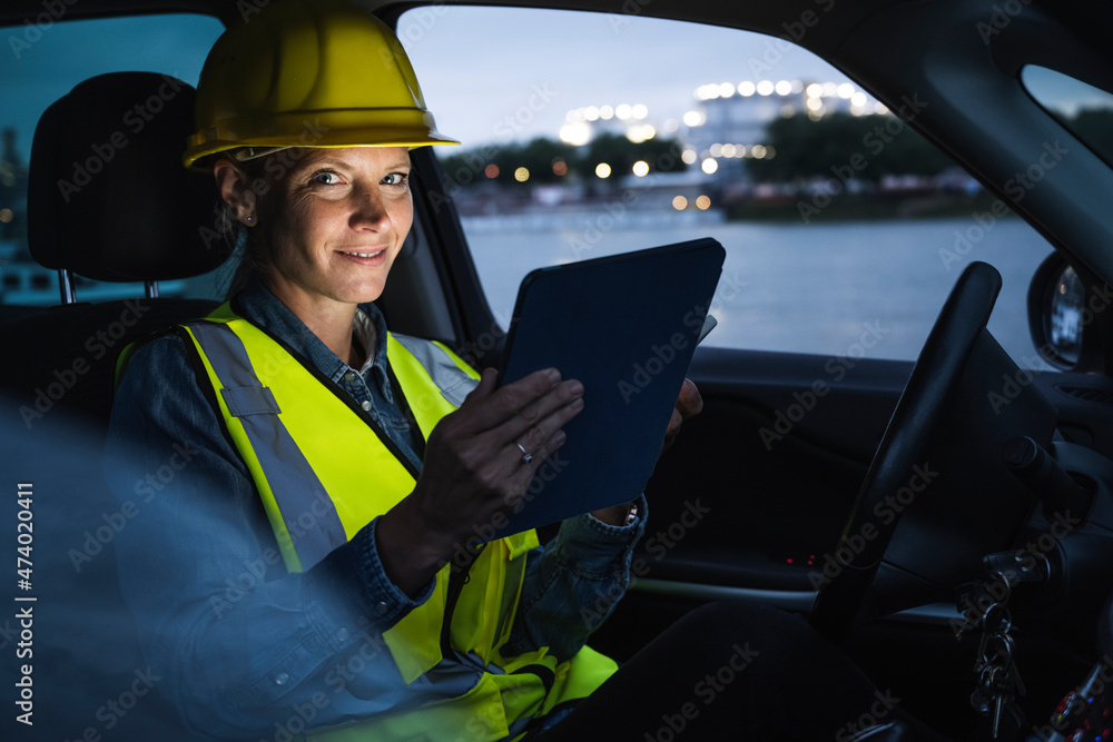 Smiling female professional holding digital tablet while sitting in car Smiling female professional holding digital tablet while sitting in car