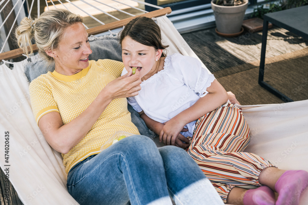 Mother feeding daughter while lying in hammock Mother feeding daughter while lying in hammock