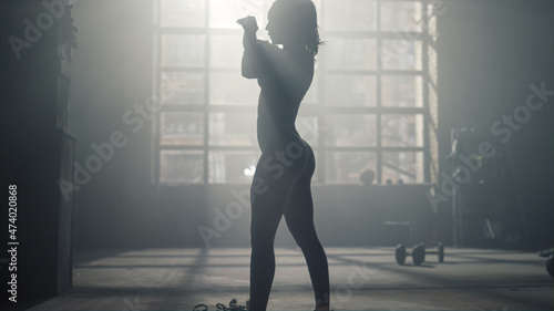 Woman preparing body for crossfit training in sport club. Athlete warming hands