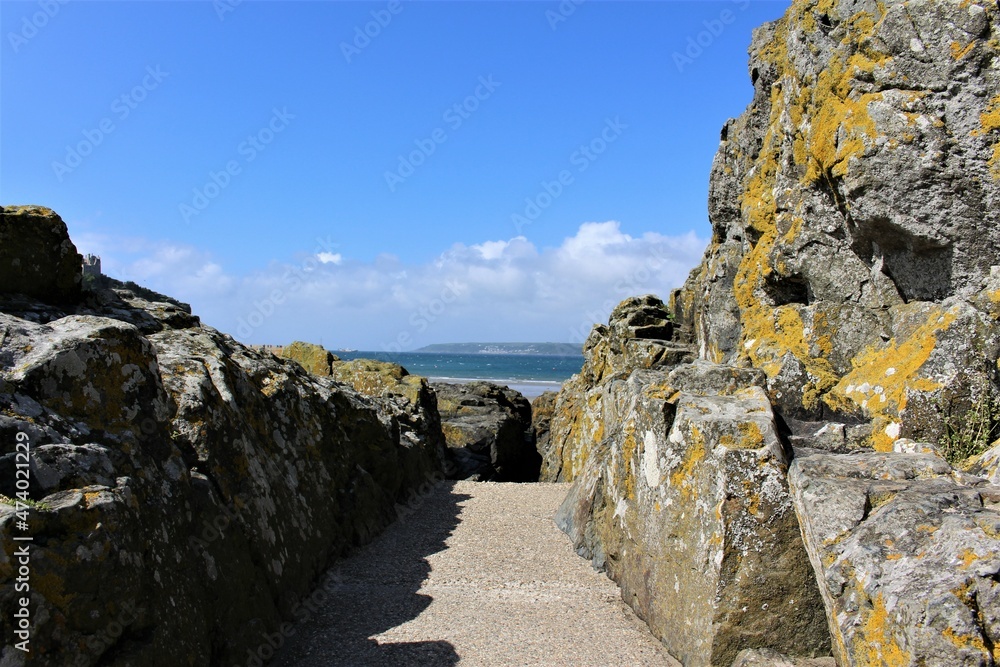 Path between cliff rocks with blue skies