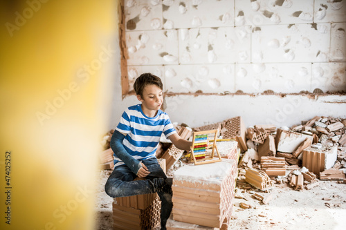 Boy counting bead of abacus toy at house during renovation