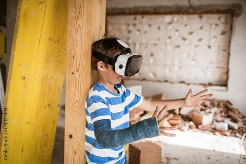 Boy with virtual reality headset stretching hand during attic renovation photo