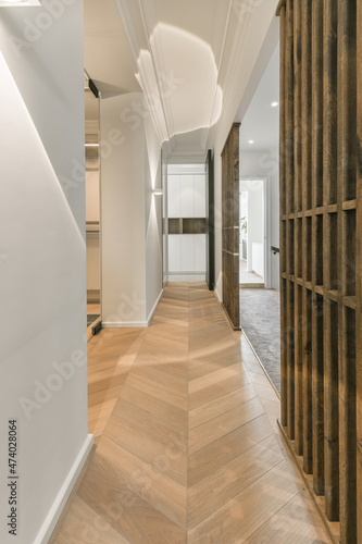 Narrow corridor with parqueted floor and gray walls photo