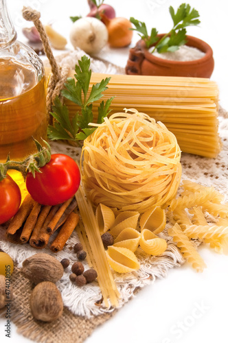 Pasta, vegetables, spices and oil on the table for Italian food