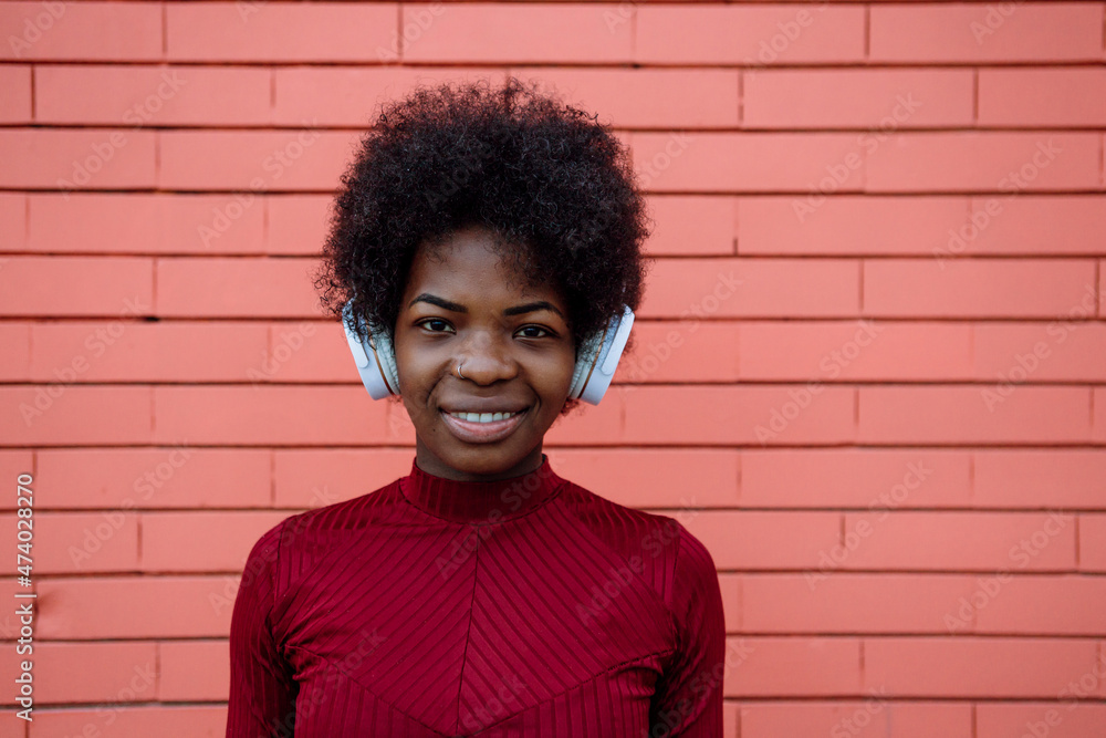 Woman with wireless headphones near brick wall Woman with wireless headphones near brick wall