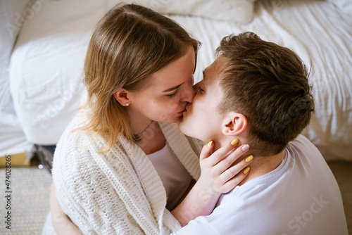 young couple a guy and a girl of Caucasian ethnicity in white T-shirts embrace kissing