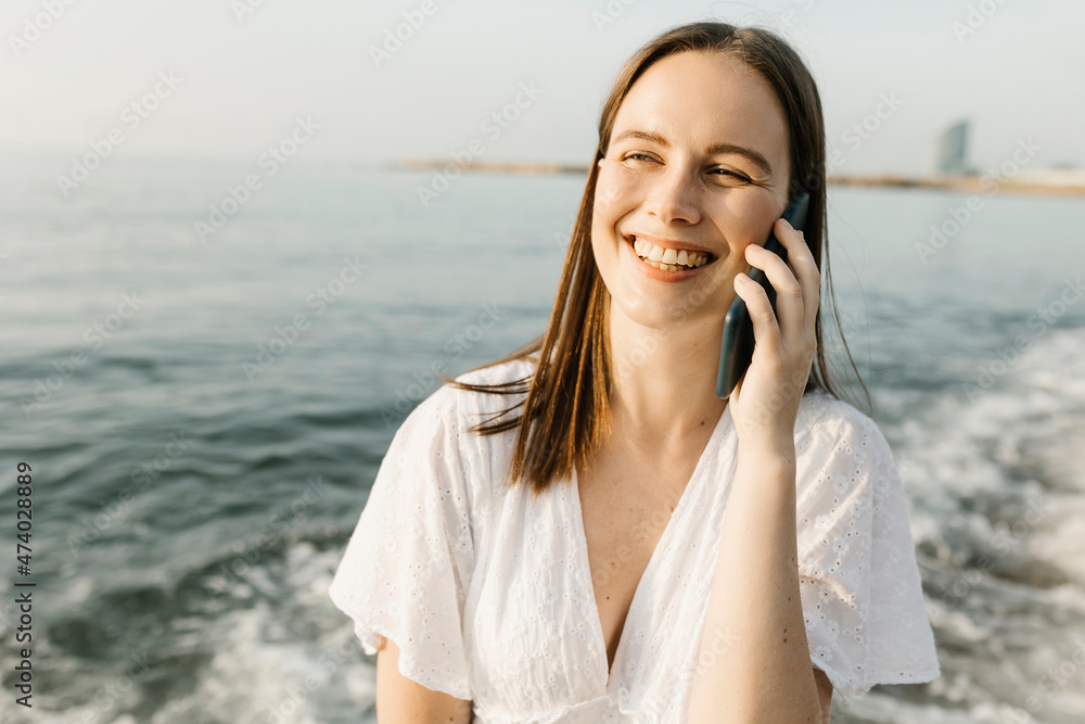 Happy woman talking on mobile phone at beach Happy woman talking on mobile phone at beach