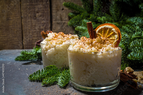 Risgrynsgrot, scandinavian-style Christmas rice porridge with cinnamon and spices, with Christmas tree branches decor 