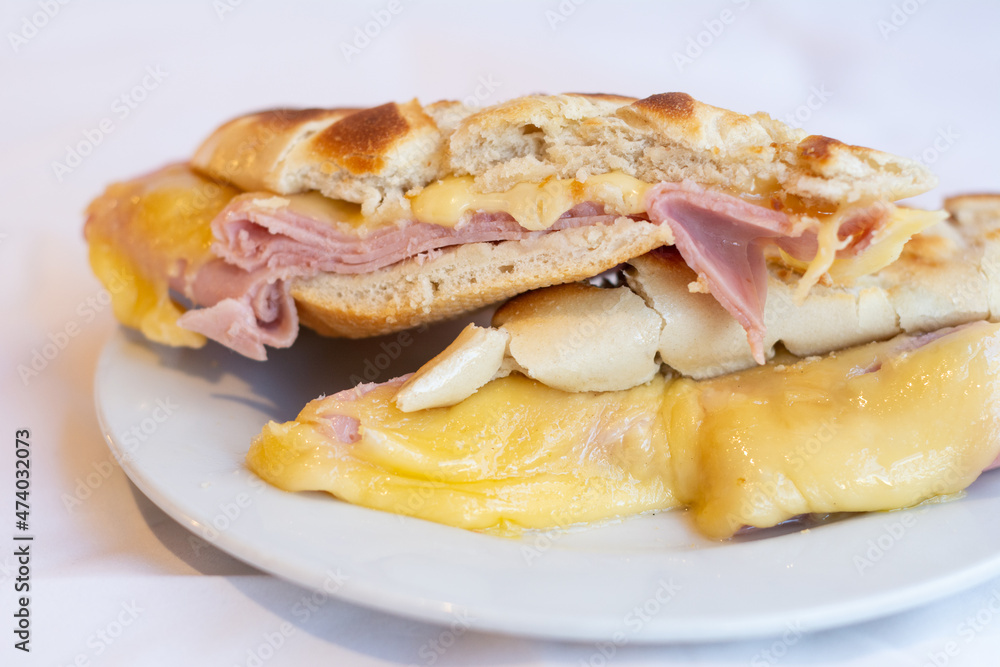 tostado de pan de jamony queso en plato cortado a la mitad