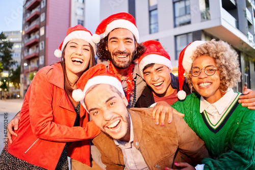 Selfie of a Group of Friends wearing Santa Claus hat. People celebrating Christmas outdoors.