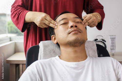 Asian Man having face massage in spa salon