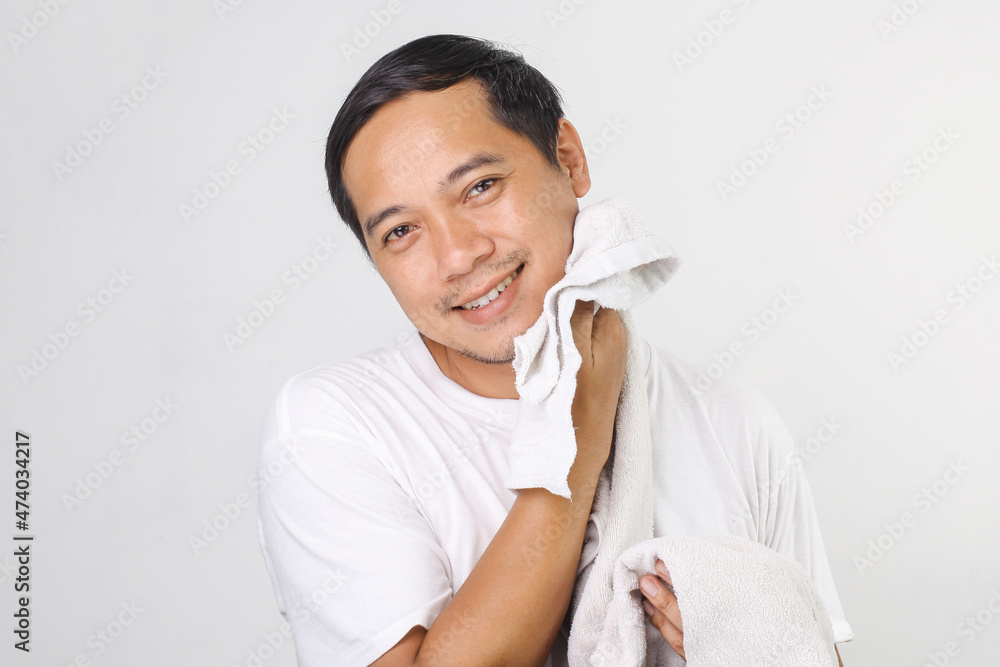 Portrait of attractive asian man wiping his face with towel after peeling, mask, moistening, making every morning procedure, looking at camera Portrait of attractive asian man wiping his face with towel after peeling, mask, moistening, making every morning procedure, looking at camera
