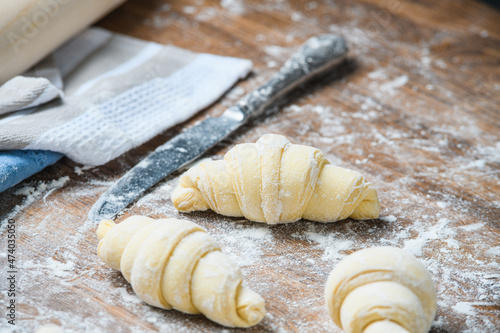The chef manually makes croissants on the table with ingredients.