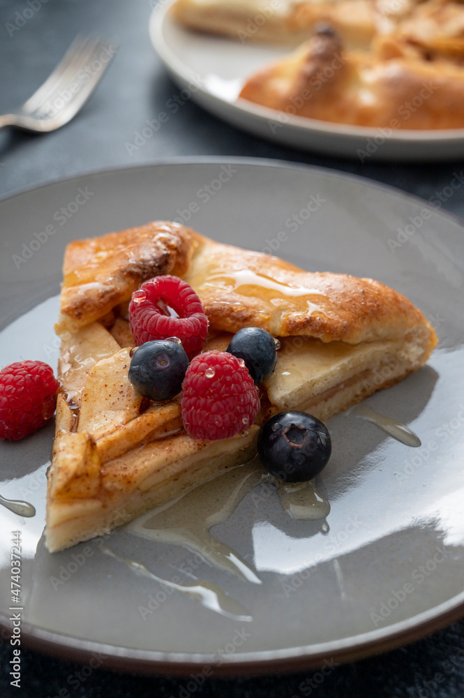 Apple tart or galette with cinnamon and fresh berries. Home baking. Apple tart or galette with cinnamon and fresh berries. Home baking.