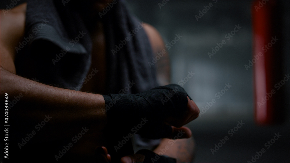 Man preparing for kickboxing fight. Guy wrapping hands with boxing tapes 