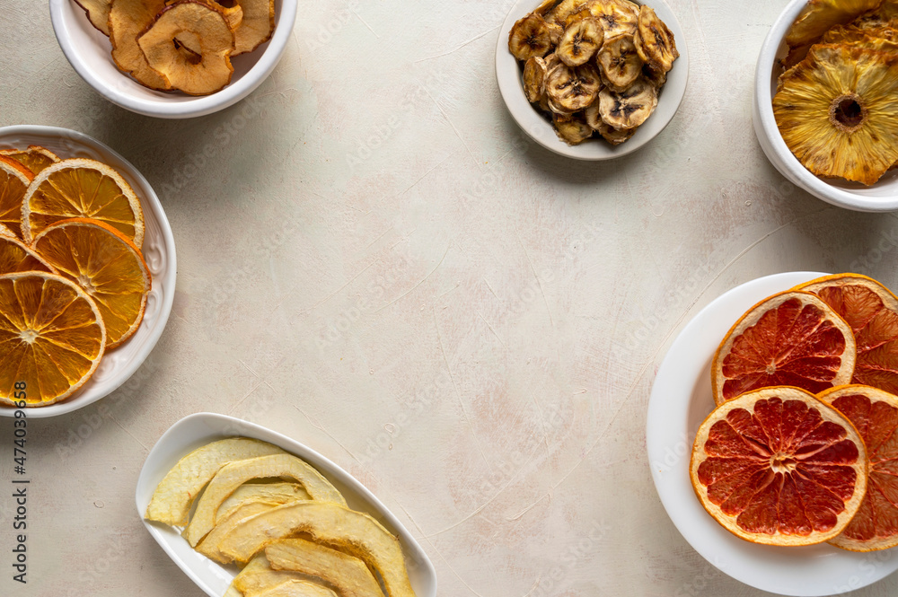 Homemade organic dried fruit slices in plates, top view. Dried orange, grapefruit, pineapples, copy space Homemade organic dried fruit slices in plates, top view. Dried orange, grapefruit, pineapples, copy space