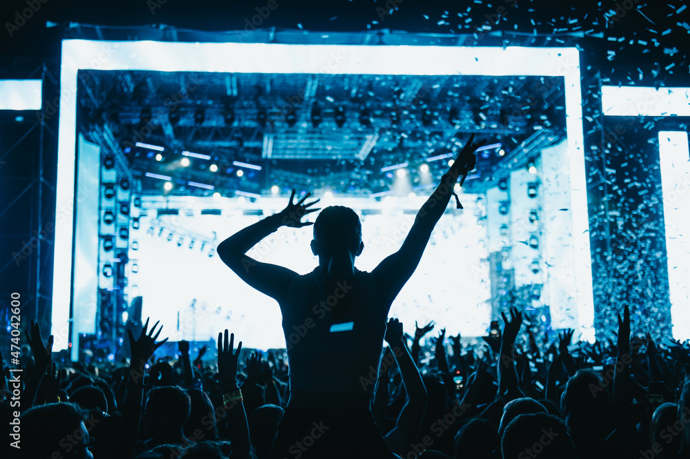 Φωτογραφία Silhouette of concert crowd in front of bright stage lights on a music festival