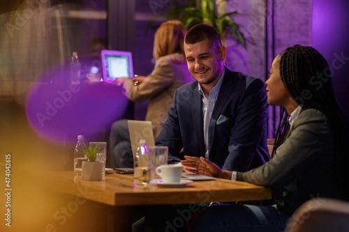 Two business people having a meeting in a cafe while using a laptop