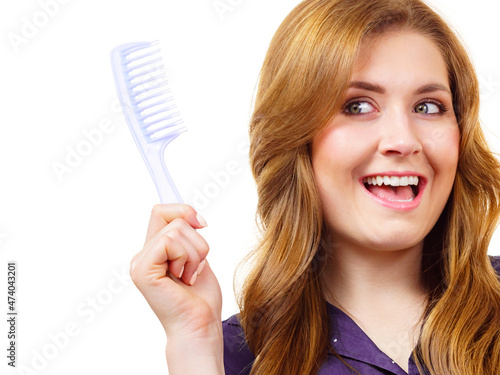 Woman long healthy brown hair holds comb