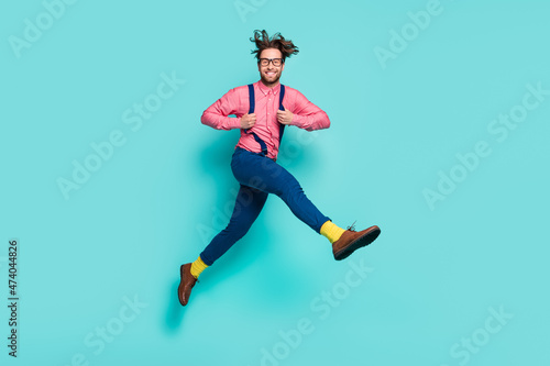Full size profile side photo of young excited man happy positive smile jump isolated over turquoise color background