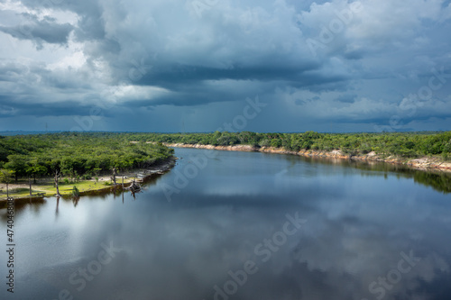 Beautiful view of Urubu River, forest trees in cloudy summer day before rain and storm in Amazon Rainforest. Manaus, Amazonas, Brazil. Concept of environment, ecology, nature, conservation, travel.