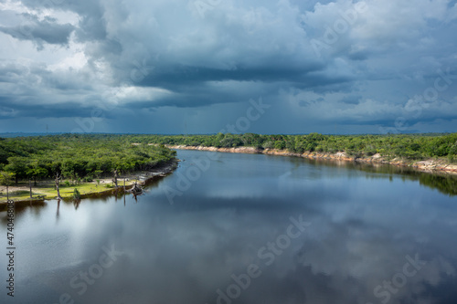 Beautiful view of Urubu River, forest trees in cloudy summer day before rain and storm in Amazon Rainforest. Manaus, Amazonas, Brazil. Concept of environment, ecology, nature, conservation, travel.
