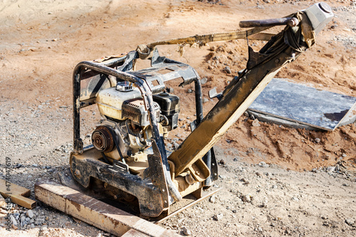 Vibratory rammer with vibrating plate on a construction site. Compaction of soil for further construction work. Close-up.