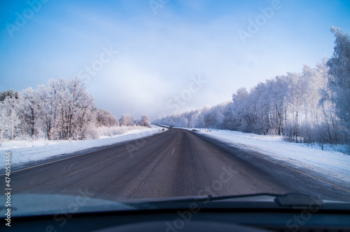 view of the winter snow-covered road from the car interior
