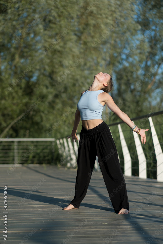 The girl dances beautifully on the embankment of the lake The girl dances beautifully on the embankment of the lake